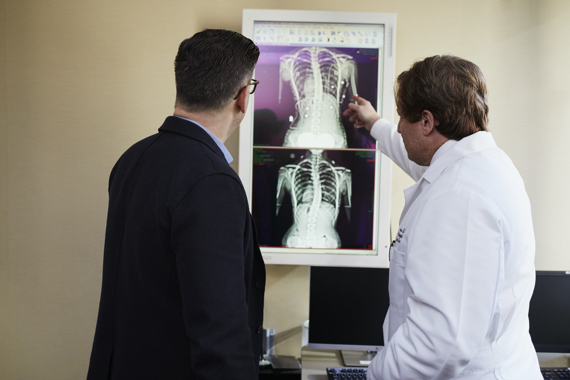 Two men looking at an X-ray on a lightbox one is a doctor